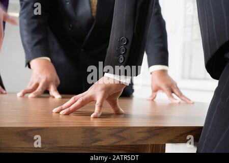 Midsection of people standing around a table. Stock Photo