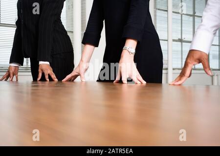 Midsection of people standing around a table. Stock Photo