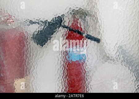 silhouette of the fire extinguisher behind the glass. building fire safety Stock Photo