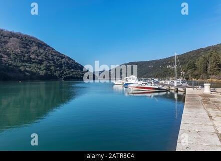 LIMSKI KANAL, CROATIA - January 29, 2020: Anchored boats in a sunny port in the Lim Canal, Istria, Croatia Stock Photo