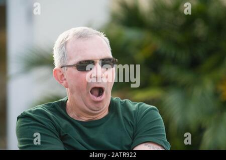 Close-up of a senior man yawning