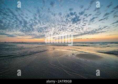 Beautiful landscape image of sheep clouds and twilight colors in the sky at the dutch coast Stock Photo