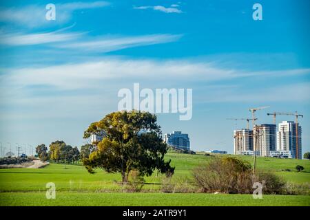 construction site seen from a beautiful green wheat field Stock Photo