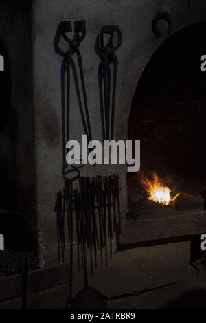 The old tools in the blacksmith's shop. Fire forge in the smithy. Stock Photo