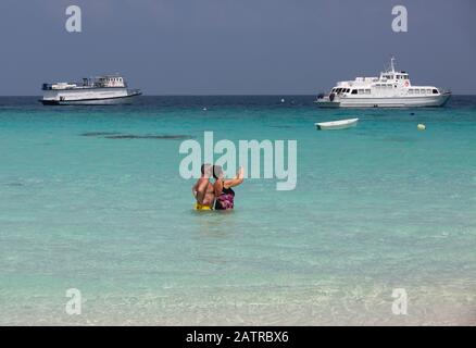 Maldives holiday - A middle aged couple taking a selfie photo in the Indian Ocean on a beach in the Maldives, Asia Stock Photo