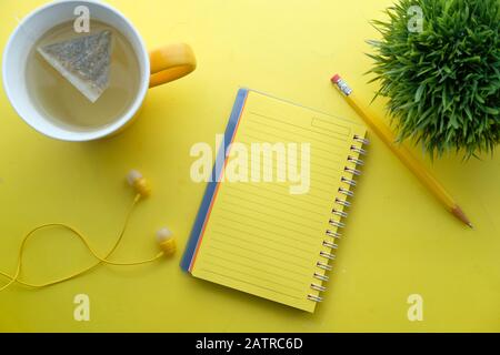 top view of open notepad and tea on yellow background  Stock Photo