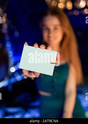 Gift card. Excited woman showing blank paper card sign with copy space for text. isolated on blur background Stock Photo