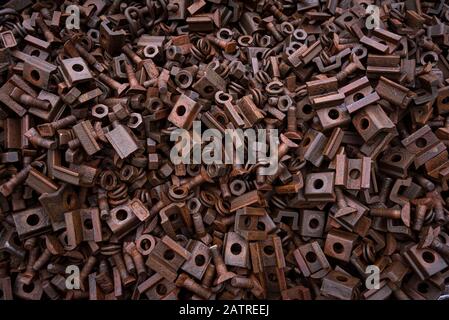 Old metal collected for recycling. Pile of rusty iron screws and screw nuts from old railways. Huge pile of old metal pieces Stock Photo