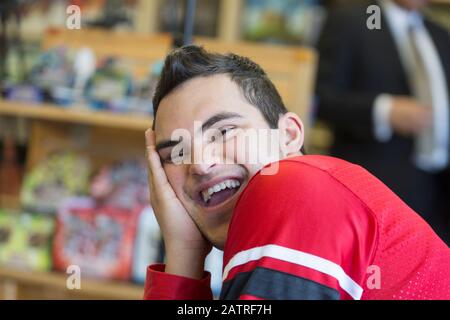 Middle Eastern man with Down Syndrome smiling at work Stock Photo