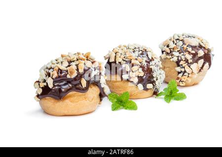 Homemade  profiteroles covered with chocolate and chopped nuts isolated on white Stock Photo