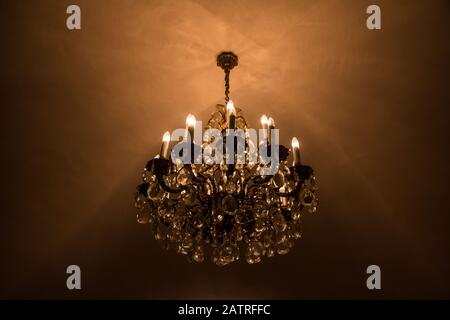 The detail of the old vintage crystal chandelier with lights turned on. Stock Photo