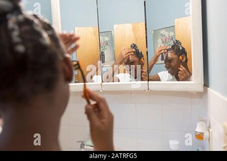 Teen suffering from Bipolar Disorder doing her hair Stock Photo