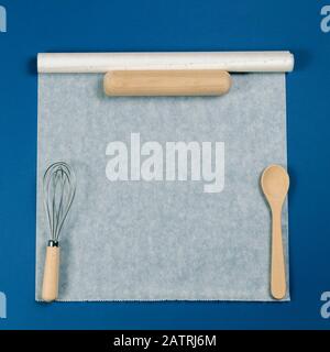 https://l450v.alamy.com/450v/2atrj6m/wooden-spoon-rolling-pin-and-balloon-whisk-over-white-baking-paper-on-blue-background-top-view-flat-lay-2atrj6m.jpg