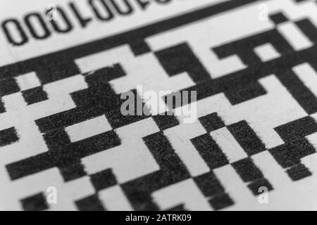 Abstract monochrome close up of isolated printed QR data matrix bar code on white paper label background from material inventory tracking system Stock Photo