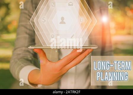 Writing note showing Long Term Planning. Business concept for establishing goals that you expected to achieve Stock Photo