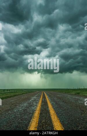 An empty highway disappears into the mouth of a storm somewhere in the Texas Panhandle; Texas, United States of America Stock Photo
