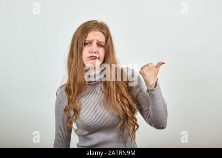 woman in gray sweater is dissatisfied an angry girl points finger in direction Stock Photo