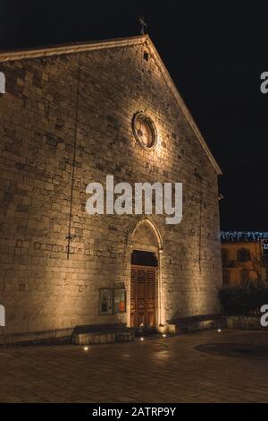 A medieval stone church at night lit with warm light in an old French village (Jan 10, 2020) Stock Photo