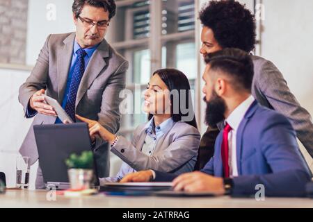 Business people having meeting around table in modern office Stock Photo