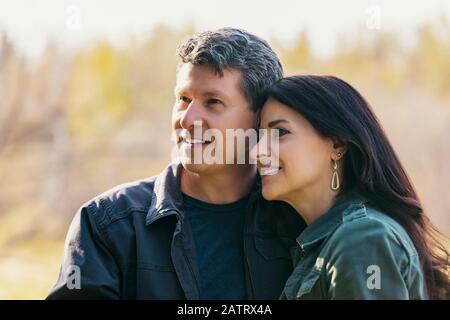 A mature husband and wife enjoying quality time together outdoors in a city park during a warm fall evening; St. Alberta, Alberta, Canada Stock Photo