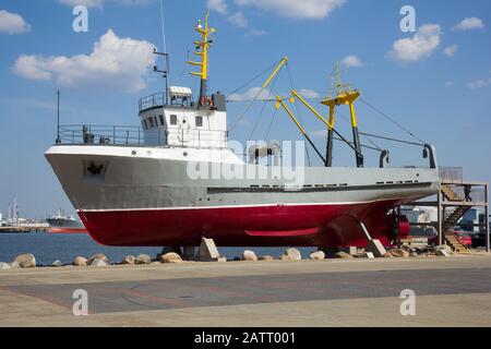 old fishing boat on postament as tourist attraction in Latvia, Ventspils Stock Photo