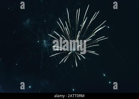 Cheap bluish fireworks against the dark sky. Stock Photo