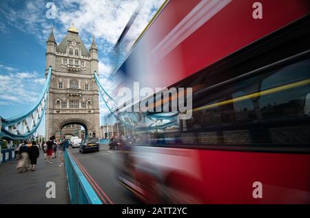 People walking and red traditional London bus crossing the famous London Tower bridge Stock Photo