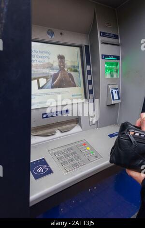Someone about to use a cash machine, an Automated Teller machine or ATM, England, UK Stock Photo