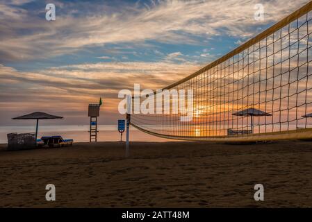 volleyball net and sunbeds on a sandy beach at sunset in the Red Sea, el Gouna, Egypt, January 16, 2020 Stock Photo