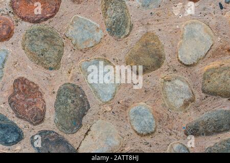 Road is lined with natural stones of various sizes and colors. Vintage stone background. View from above Stock Photo