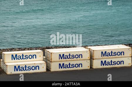 Kahului, Maui,, Hawaii, USA. - January 13, 2020: Ocean port. Closeup of white Matson shipping containers stacked on quay with azure ocean as backdrop. Stock Photo