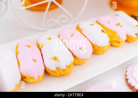 Candy Bar. custard cakes on the table decorated with gold leaf. Dessert close up Stock Photo