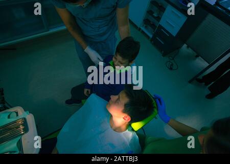 Teenage boy with his younger brother sitting on the dentist chair waiting for a regular dental checkup Stock Photo