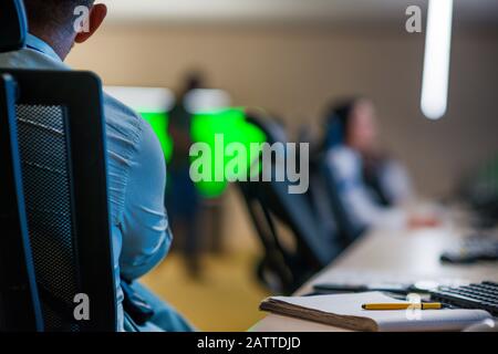 Security guard monitoring modern CCTV cameras in a surveillance room. Stock Photo