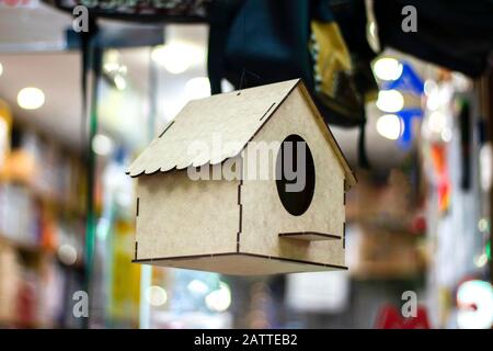 Light wood color bird house. It hangs in the air. Photographed in front of the store and for sale. Close up Stock Photo