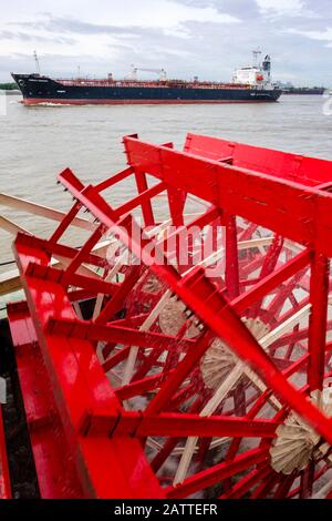 Paddle boat, steamboat SS Natchez detail, with cargo ship on background, Mississipi River, New Orleans, Louisiana, USA Stock Photo