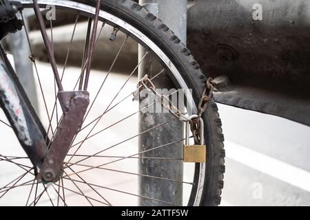 Lock a bicycle with chain and pole on footpath Stock Photo