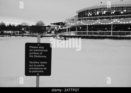 Ice skating sign: 'Please stay on maintained surface of the Skateway'. Rideau Canal Skateway in front of Dow's Lake Pavilion, Ottawa, Ontario, Canada. Stock Photo