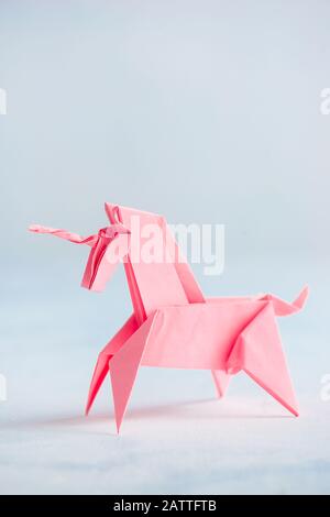 Pink origami unicorn on a light background Stock Photo
