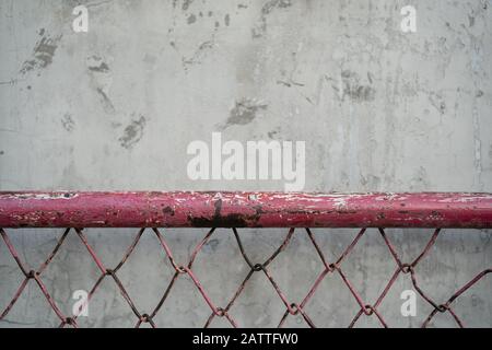 Concrete texture with red chain link fence Stock Photo