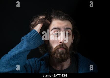 Hipster man solves a problem and thinks. Shot on black isolated background. Thinks Concept. Stock Photo