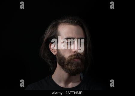 Hipster man solves a problem and thinks. Shot on black isolated background. Thinks Concept. Stock Photo