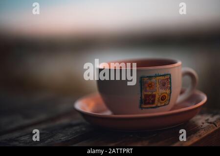 Tea or coffee cup with flower decor on the table in the outside. Coffee Concept. Stock Photo