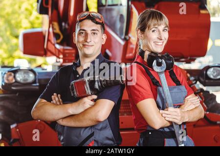 Two machinists for farm machinery in their garage Stock Photo