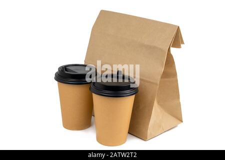 two disposable paper cups and a paper bag with food isolated on a white background Stock Photo