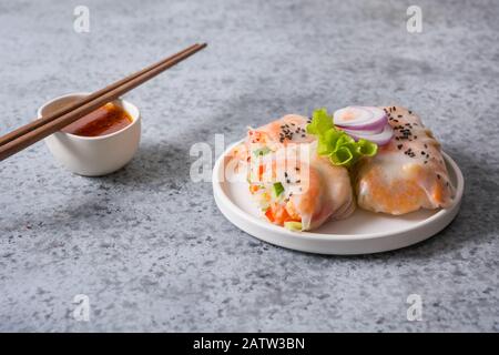 Vietnamese spring rolls with shrimps, noodles, vegetables on grey background. Close up. Asian cuisine. Stock Photo