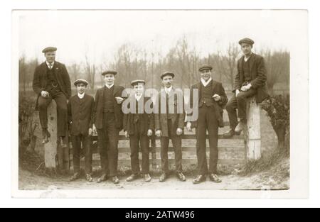 Early 1900's postcard of young Edwardian men wearing Sunday best suits and flat caps on a day out walking in the countryside, U.K. circa 1910 Stock Photo