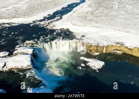 Aerial view of Godafoss waterfall, snowy shore and river. Iceland in early spring Stock Photo