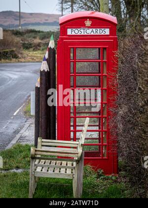 An old K6 type red telephone booth which has been converted into a small shop and information centre. This box is located on a hillroad in the scottis Stock Photo