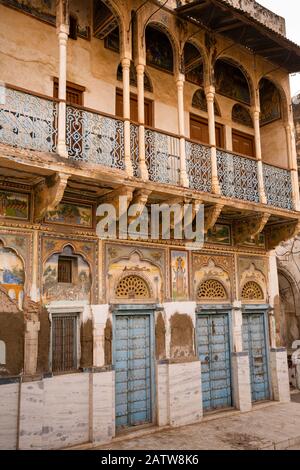 India, Rajasthan, Shekhawati, Ramgarh, blue painted doors of well-maintained old haveli, with lower decorative painted whitewashed over Stock Photo